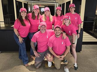 System1's innovation team pictured wearing pink branded company T-shirts and caps